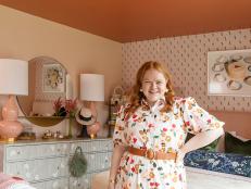 Fashion influencer Allie Provost smiles in her pink NYC bedroom. 