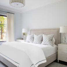 Neutral Coastal Bedroom With Upholstered Headboard and Pendant Lamp 