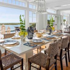 Traditional White Coastal Dining Room With Waterside Views and Wicker Chairs 