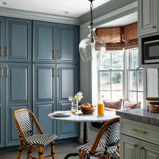 Transitional Breakfast Nook With Blue Cabinets and Black and White Bistro Chairs 