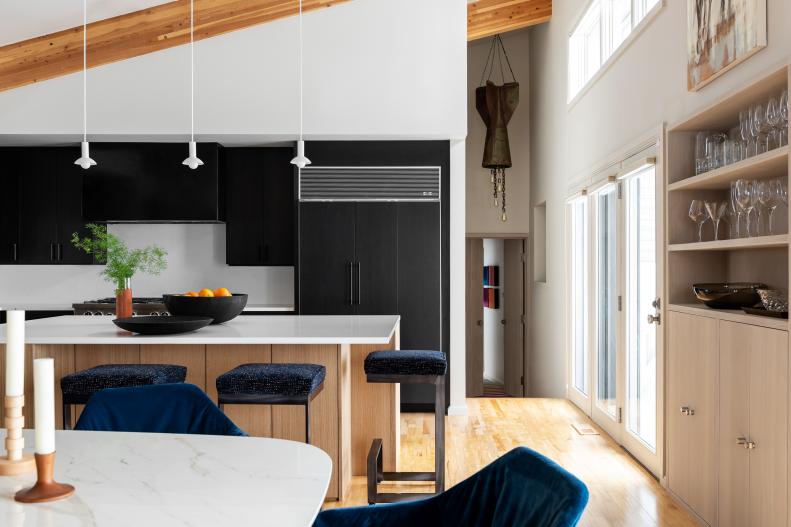 Hallway with half-rocket chandelier and black cabinets.