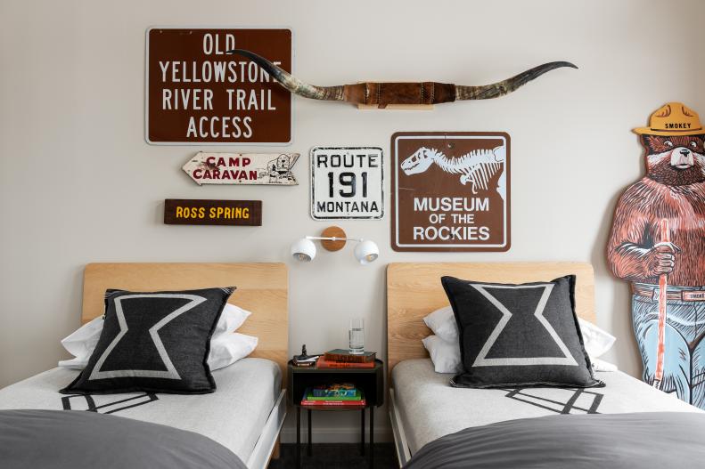 Double bedroom with grey sheets and national park signage. 