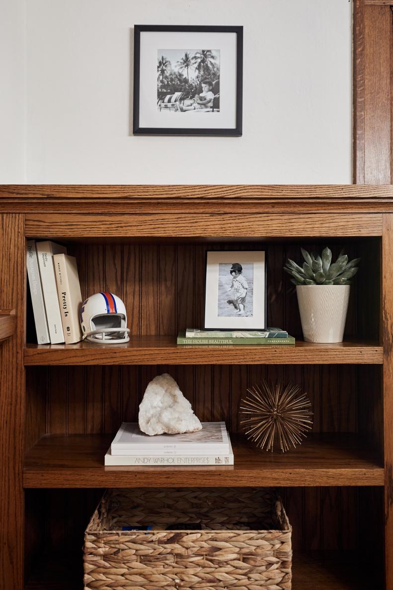Light-colored books, vases and accent pieces stand out against the wood in these dining room bookshelves.