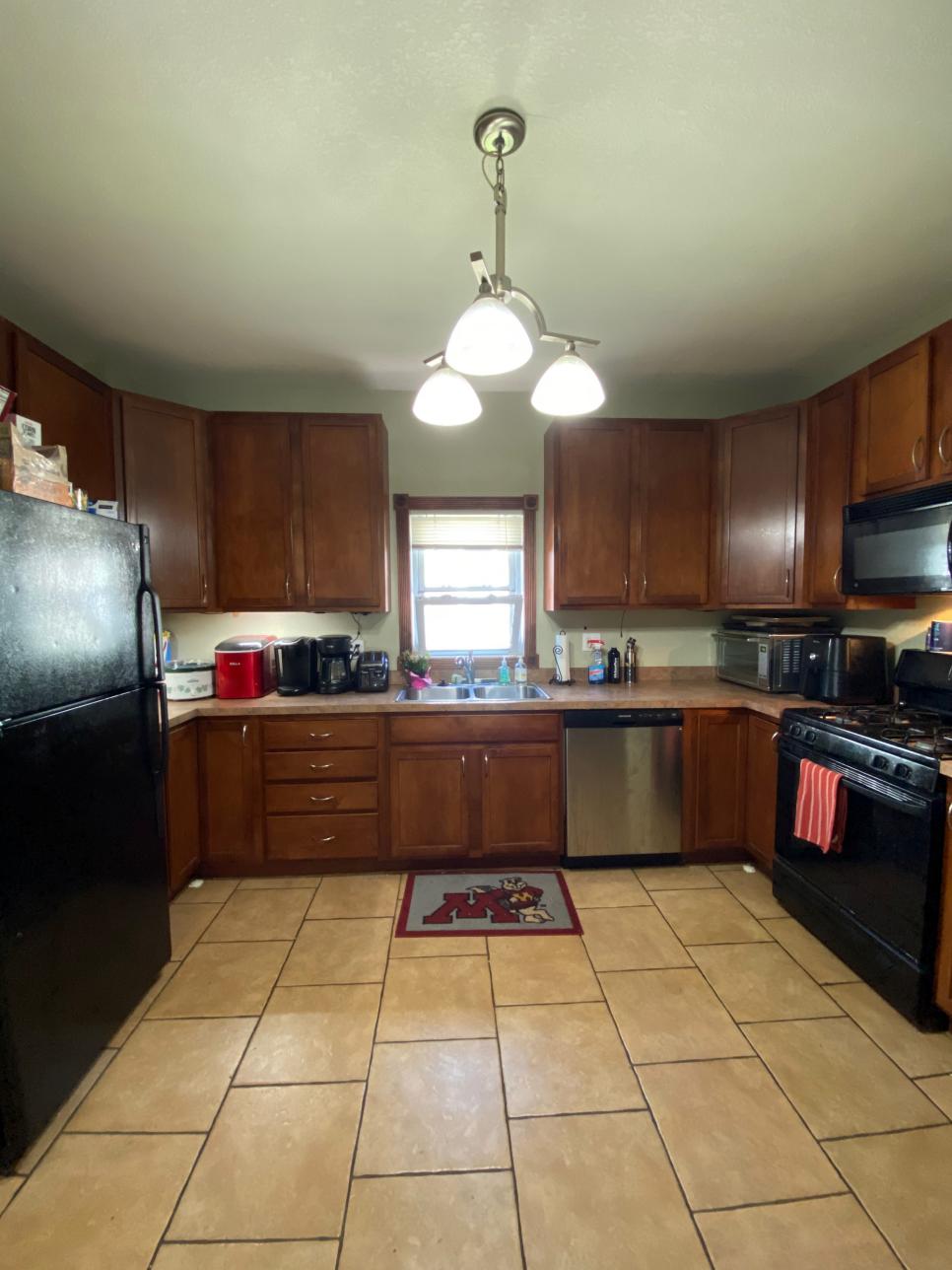 A Dark Kitchen With Green Walls and a Low Hanging Light Fixture HGTV
