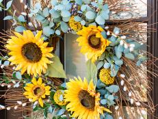 Give your porch, patio or foyer an autumnal update with this easy-to-craft fall wreath that pairs a sunburst shape with faux sunflowers for DIY fall decor that'll brighten up any spot — either indoors or out.