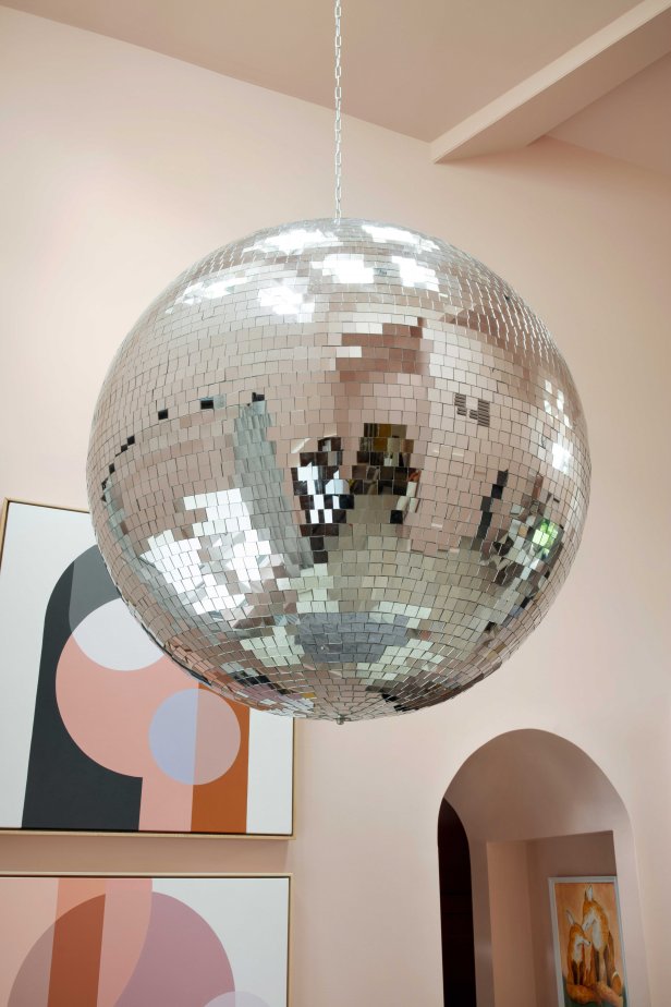 A 40-inch disco ball made from polyfoam with reflective glass mirror tiles makes a big statement above the dining table. The disco ball is extra resistant to cracking, and sure to add a fun party vibe to any get together. “We put it in the corner, so it doesn’t cast a ton of reflection all over the house,” says designer Brian Patrick Flynn. “It gives the space a memorable identity.”