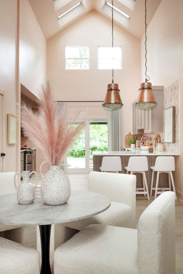 Oversized copper lights hang above a spacious peninsula that helps define the kitchen and create separation from the open dining room.