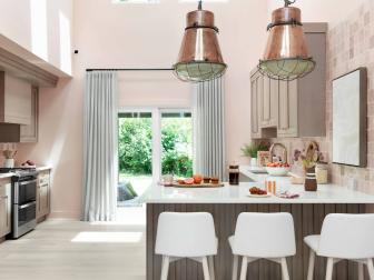 Blush-colored walls and a massive high ceiling add an expansive feel to this open kitchen, with a beautiful backyard made for easy outdoor entertaining located just steps away.