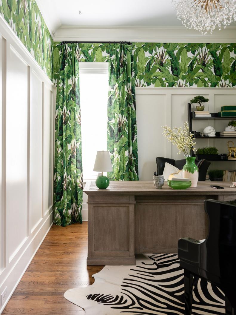Designer Brenna Morgan does monochromatic. Palms on the matching wallpaper and curtains pop against the white wall paneling, gray desk and black leather wing chairs. A cowhide and beaded ceiling pendant add to the room’s whimsical feel. 