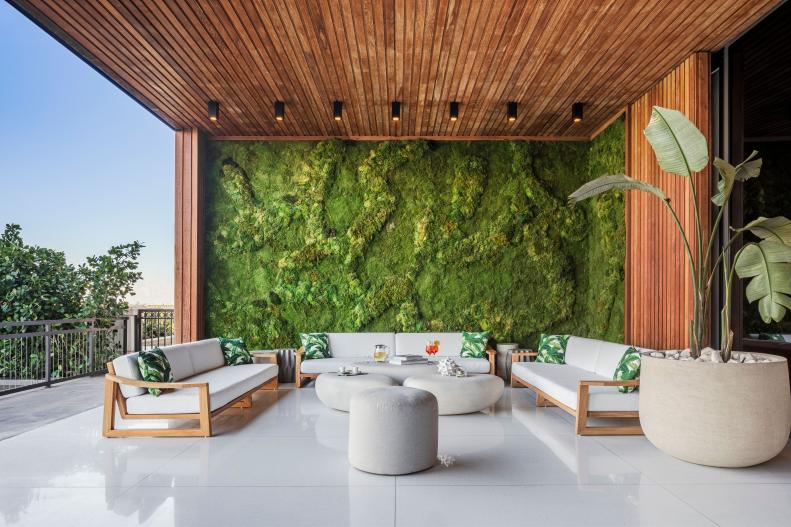 An open-air lobby with a green moss wall