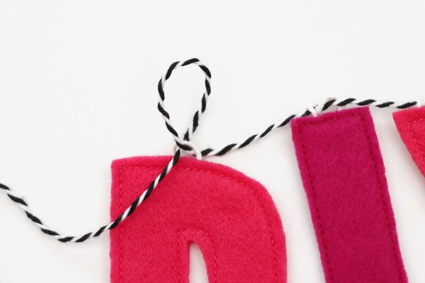 To string the letters onto the banner, cut a long piece of string and wrap it twice around each hanger. Make any phrase you want!