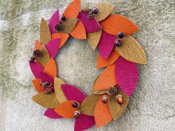 Gently pull up the leaves and glue downfall festive flourishes evenly spaced around the wreath to complete the look. Tip: Get creative with this, go outside and collect mini pine cones, acorns, or even branches.