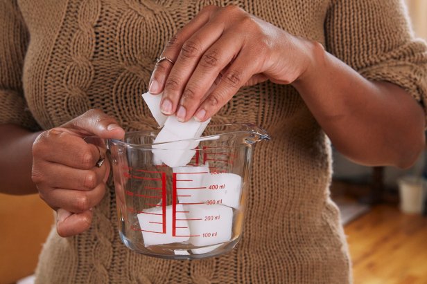 First, chop the melt and pour soap base into four columns; each column is about 1 oz. Next, cut the columns into small squares as this will help the soap melt faster. Add the squares to a glass measuring cup. Note: Because the soap base is already cured, your tools will remain food safe. Then place the measuring cup into a double boiler on low-to-medium heat and stir the cubes with a spatula.