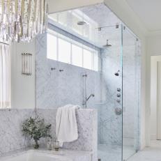 A Marble Shower and Bathtub and Large Crystal Chandelier Make This Principal Bathroom Feel Elegant