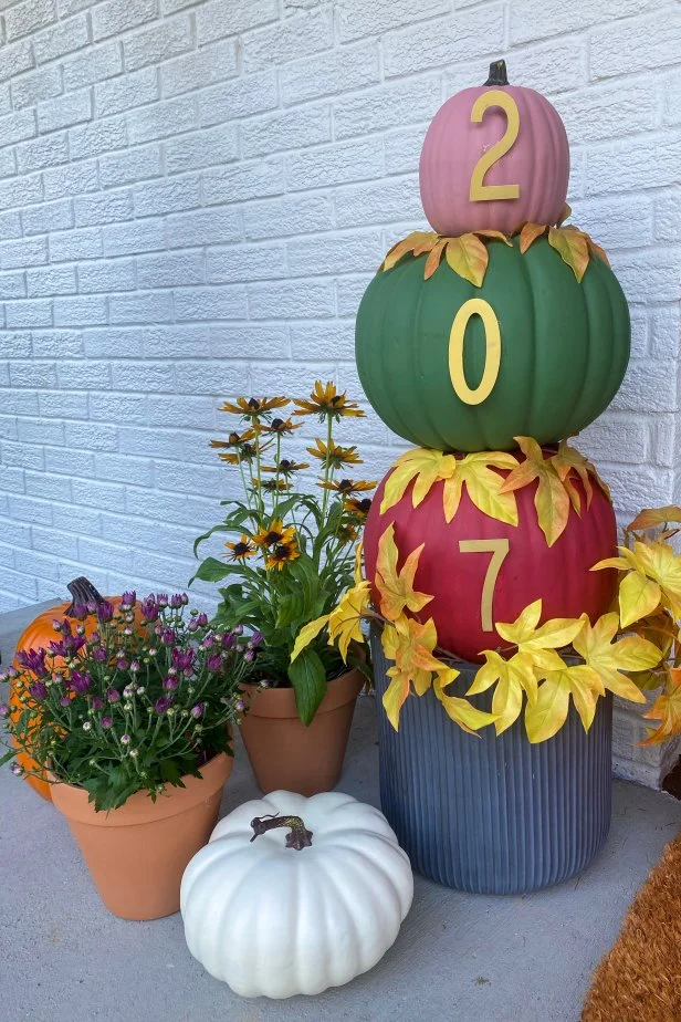 HGTV Handmade’s Danielle Boaz shares a fresh fall how-to for making a house number pumpkin topiary. To make your own, you will need a small, medium and large faux pumpkin, rust red, mauve and forest green craft paint, a large planter, super glue, plain metal numbers, gold spray paint, sponge brush and a utility knife.