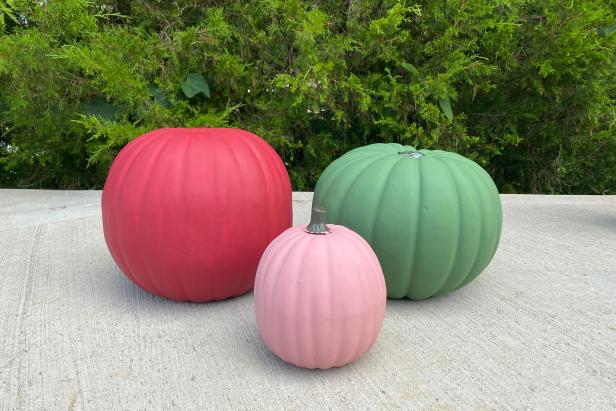 Start with three different sizes of faux pumpkins: small for the top, medium for the middle and large for the base of the topiary. Use a utility knife to carefully remove the stems from the medium and large faux pumpkins. Note: Do not remove the stem from the small pumpkin. Create a fall jewel tone color palette by painting the largest pumpkin rust red, the medium pumpkin forest green and the smallest mauve. Use a foam brush to give each pumpkin one coat of paint and let dry. Once all the pumpkins are dry, paint a second coat on each pumpkin to ensure a deeper color.