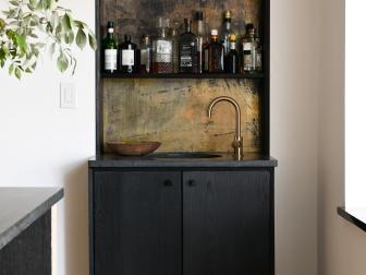 Steve and Leanne Ford preserved a mirror from the Bell's home during the renovation to use it in this new bar area next to the kitchen, as seen on HGTV's Home Again with the Fords. They used chemicals to give the mirror an aged look, which made the bar pop even more in the room.