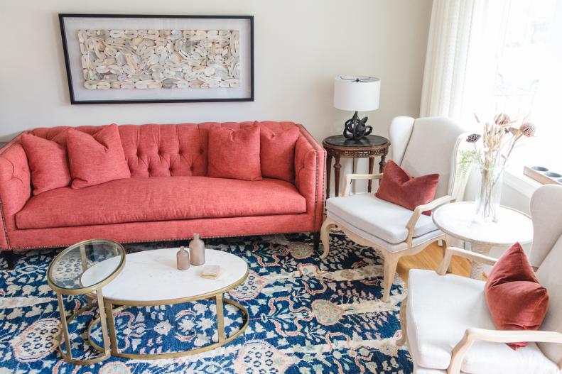 White living room with blue rug and peach sofa. 
