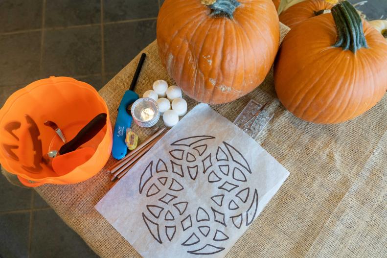 Tools and Pattern on Table Near Pumpkins, Candle and Lighter