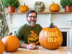 Michael Anthony Natiello poses with a pumpkin carved with the HGTV Handmade logo