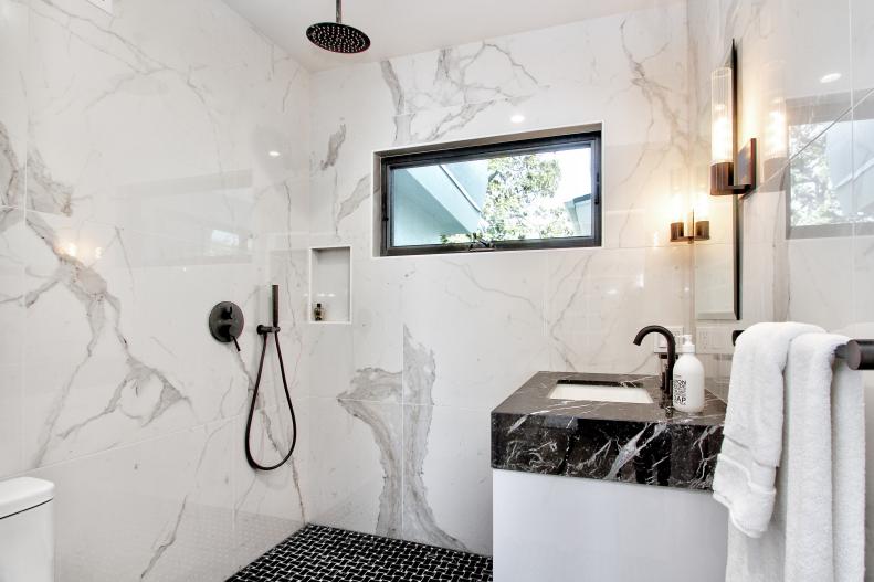 This small quartz bathroom has the shower head on the ceiling.