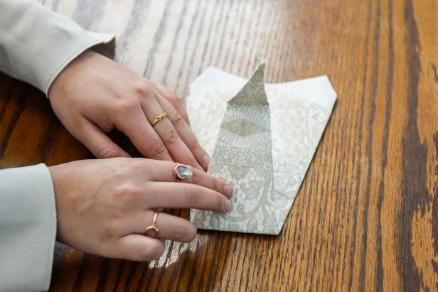 The next step in creating this Thanksgiving turkey paper napkin fold is to stand the neck up.