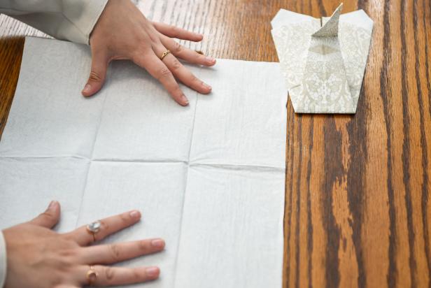 The next step in creating this Thanksgiving turkey paper napkin fold is to unfold a second paper napkin.