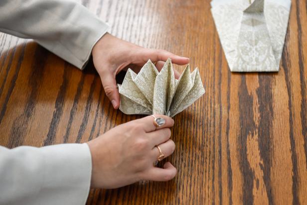 The next step in creating this Thanksgiving turkey paper napkin fold is to unfold the tail feathers.