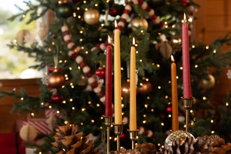 Muted Tapered Candles in Front of Christmas Tree