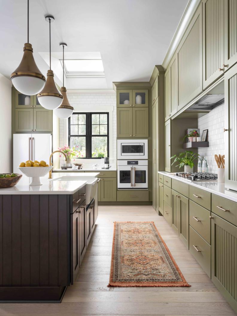 Wide traffic lanes between the cooktop wall and center island allow for good flow in, out, and around this user-friendly space with a traditional English kitchen look.