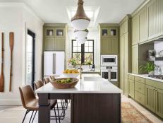 The kitchen’s matte white appliances with brushed bronze hardware offer a clean and timeless look. “It’s all about how sexy and sleek these were with the white and gold, and green cabinets,” says designer Tiffany Brooks.