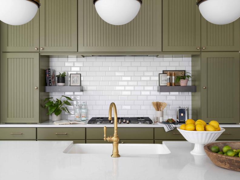 Doors on the upper cabinets that surround the cooktop area include a beadboard detail that emulates a traditional look. A subway tile backsplash provides a crisp and clean backdrop that allows the rich cabinets and sleek smart appliances to shine.