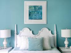 The guest bedroom is a study in blue and white. “This blue bedroom is a fresh take on monochromatic,” says Kalyn. “The blue is soothing, yet vibrant enough to be interesting.” Crisp white furnishings were brought in as a contrast to the Tiffany Blue shade. “I fell in love with the vintage Hollywood Regency headboard, and it became the inspiration for the design. The feel leans toward glam, but still manages to fit into this cottage home.”    
