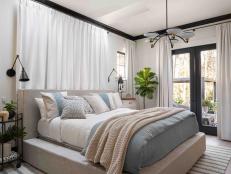 A king-sized smart bed with adjustable base sits center stage in this serene main bedroom, with space for sleeping, relaxing, and enjoying the stunning location of this Wilmington, North Carolina home.