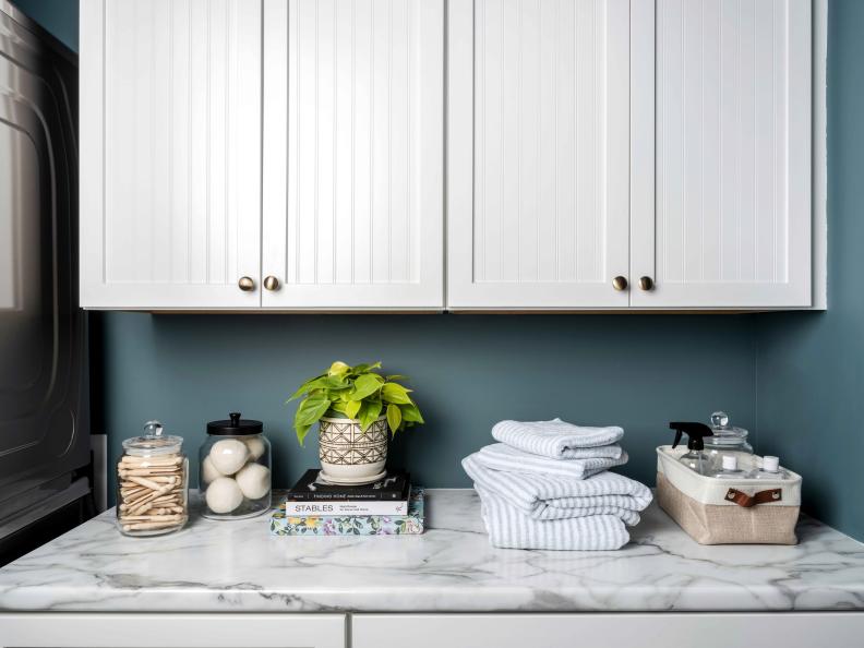 A spacious counter provides space for folding clothes, displaying decorative items or storing a basket that provides storage for often-used laundry supplies. 