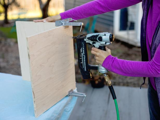 Use right-angle clamps to hold the bottom piece and one of the side pieces together. Use the brad nail gun to secure the pieces together with 1-1/4” nails.