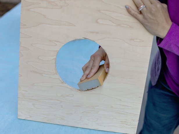 Use a 6” hole saw bit attached to a drill to create a circular opening on the front piece so your cat can easily go in and out of the hideaway. Sand until smooth.