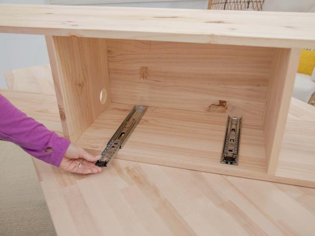 Separate the pieces of the drawer slides. Attach one piece to the bottom of the drawer and the other piece to the base of the middle section of the unit.