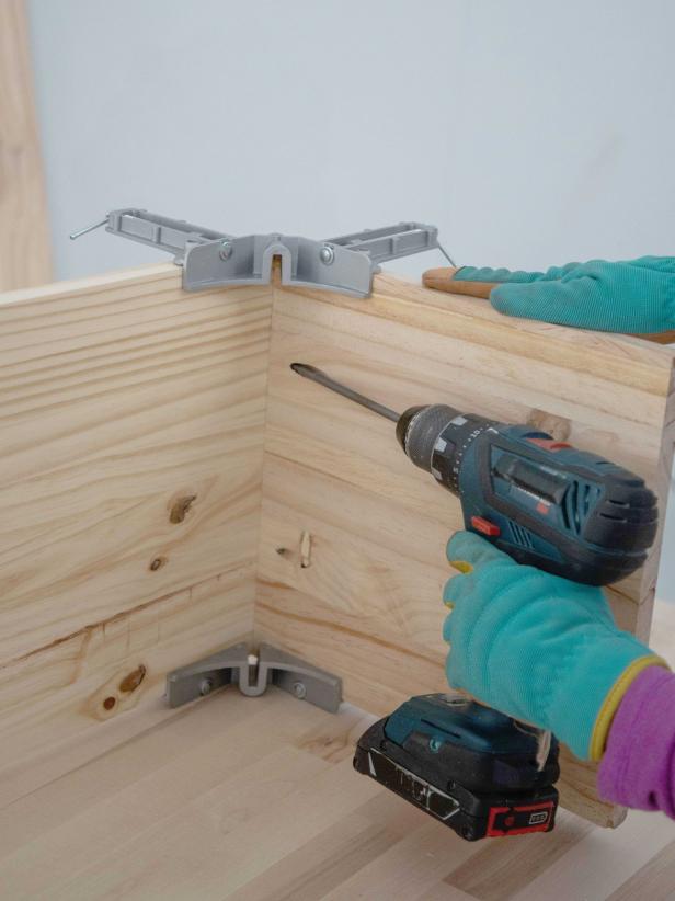 Add wood glue to the edge of one of the side pieces and use a right-angle clamp to connect it to the 12&quot; x 60&quot; bottom piece. Attach with 1-1/4&quot; pocket hole screws.