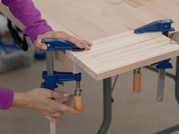 Trace the dimensions of a power strip onto one of the 6&quot; x 9-3/4&quot; drawer side pieces. Clamp the wood to the table.