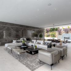 Modern Landscaping Marries Gray and White Outdoor Living Space With Nature Through Stone Fireplace and Tree Plantings
