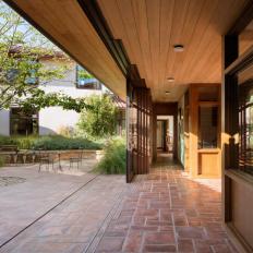 Mediterranean Residential Patio Design Melds Indoor and Outdoor Space With Warm Terracotta Tile and Sliding Glass Doors