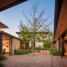 Mediterranean, Residential Courtyard Design With Centrally-Planted Tree, Terracotta Tile, and Ornamental Grasses