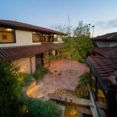 Mediterranean Courtyard Landscape Design Featuring Terracotta Patio Tile, Bistro Table, and Centrally-Planted Tree