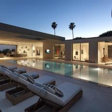 Modern, White Infinity Pool Hardscape With Welcoming Chaise Lounges, Impactful Art, and Minimalist Interior Decor