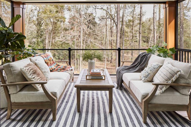 The upstairs porch at HGTV Smart Home 2022 opens to lush backyard views and provides ample seating to relax and unwind while covered from the elements