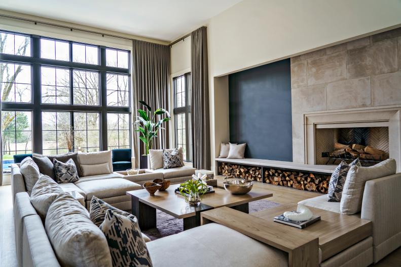 Neutral sitting room with sectional, coffee table and fireplace.