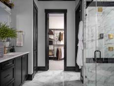 A spacious double vanity, wet room with smart shower and freestanding tub, water closet with high-tech toilet, and rick black, brass and gold design details give this main bathroom a luxe look and high-end feel.