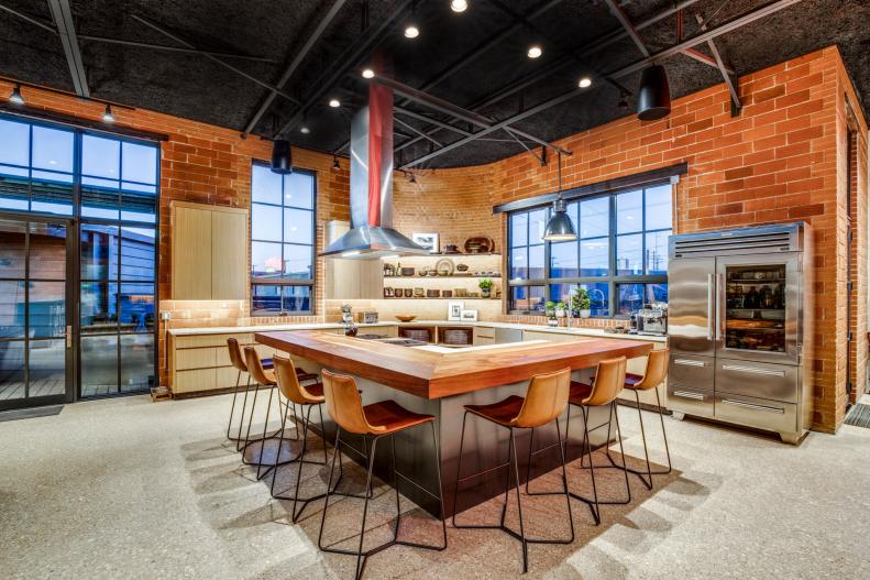 Eat-in industrial kitchen with beamed ceiling and brick walls. 