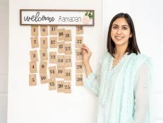 Woman Stands Smiling Beside Welcome Ramadan Advent Calendar